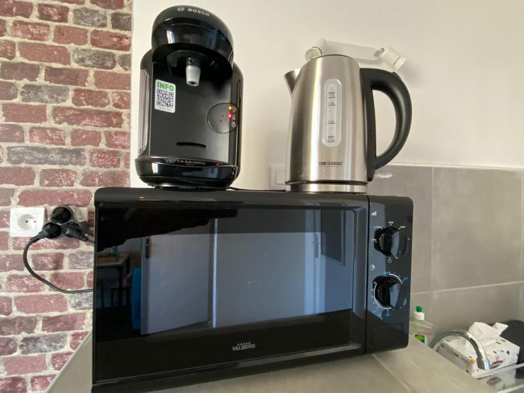 a coffee maker sitting on top of a microwave at Le Petit Cerf 3 &#47; Proche Disney &#47; Paris &#47; Wifi in Meaux