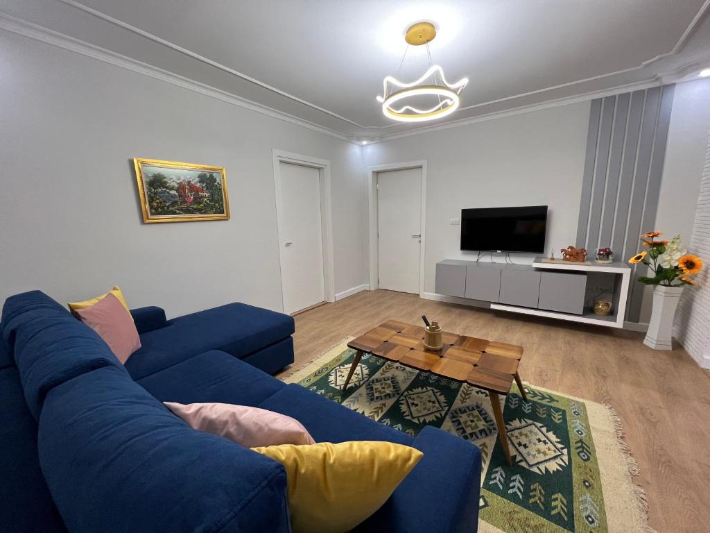 a living room with a blue couch and a table at Chestnut Yard Villa in Tirana