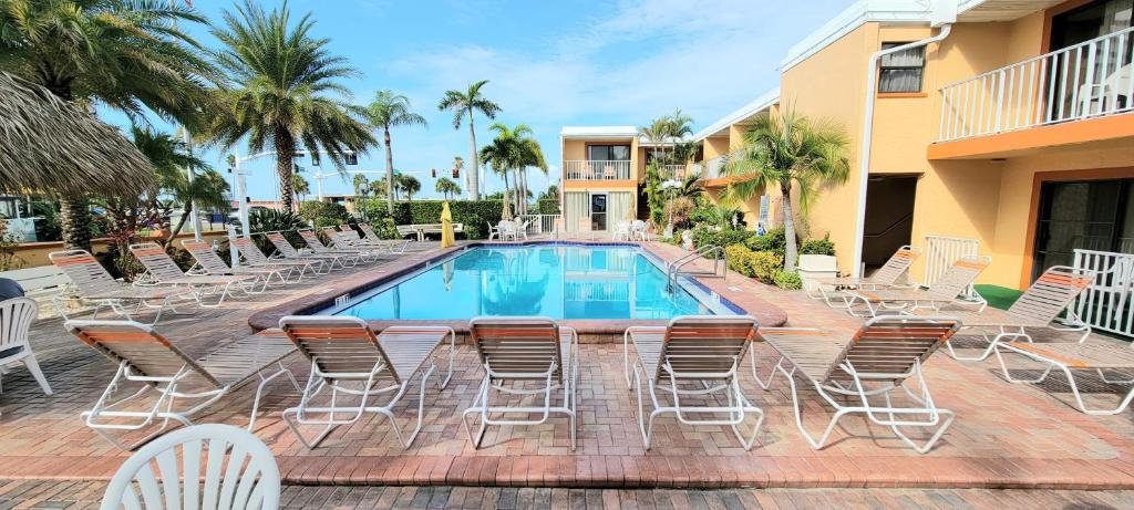 un patio con sillas y una piscina en Satellite Motel, en St Pete Beach