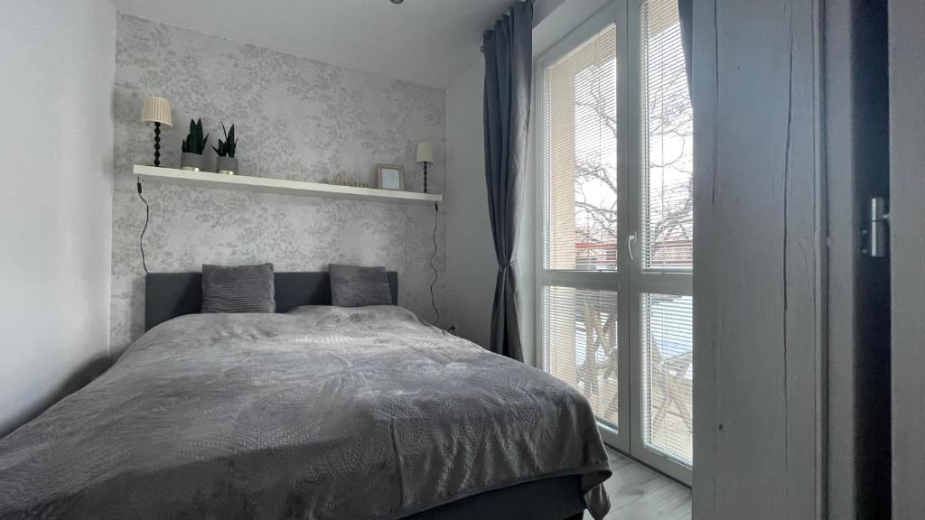 sypialnia z łóżkiem i dużym oknem w obiekcie Apartment Hospodárska w mieście Trnava