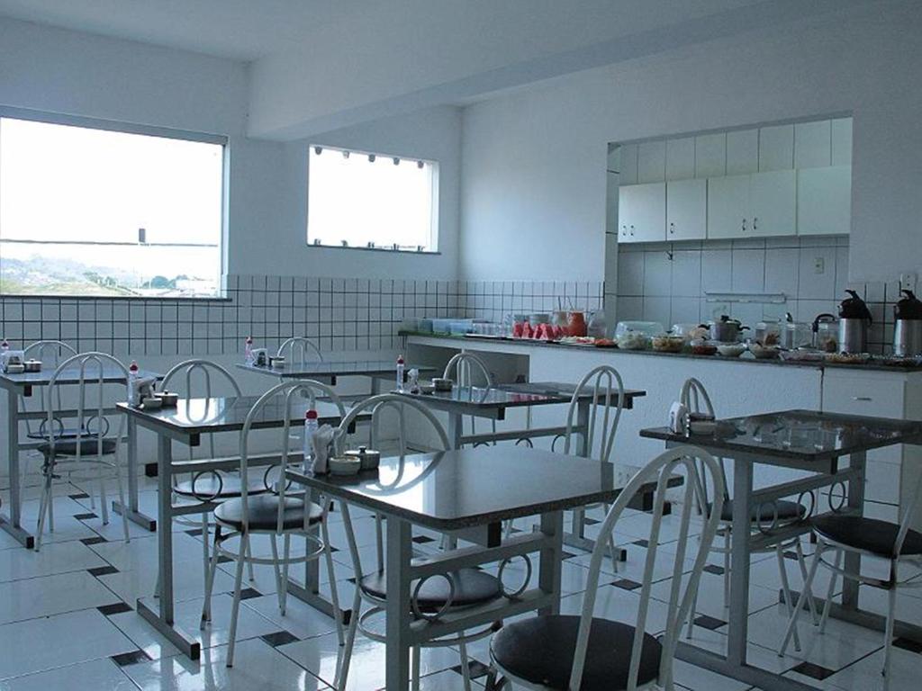 a room with tables and chairs in a kitchen at Hotel Pousada Positiva in Itabuna