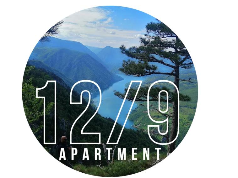 a round sign with a picture of a mountain and a lake at Apartment 12-09 in Bajina Bašta