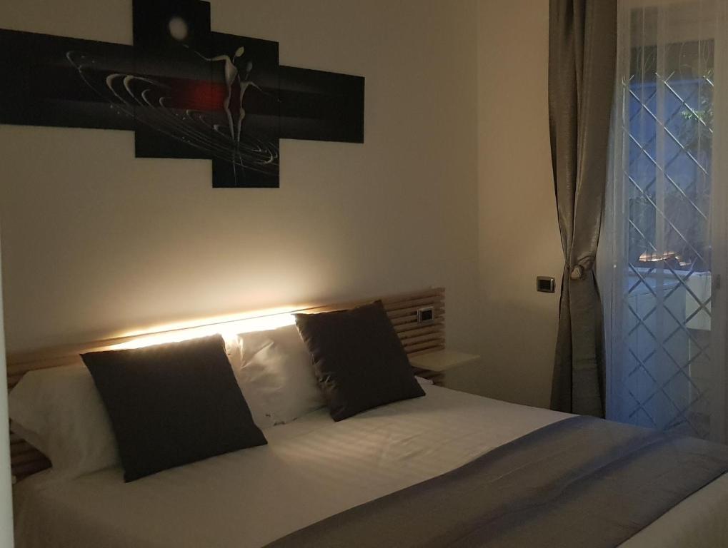 a bedroom with a bed with black and white pillows at THAT'S AMORE FIUMICINO Airport in Fiumicino