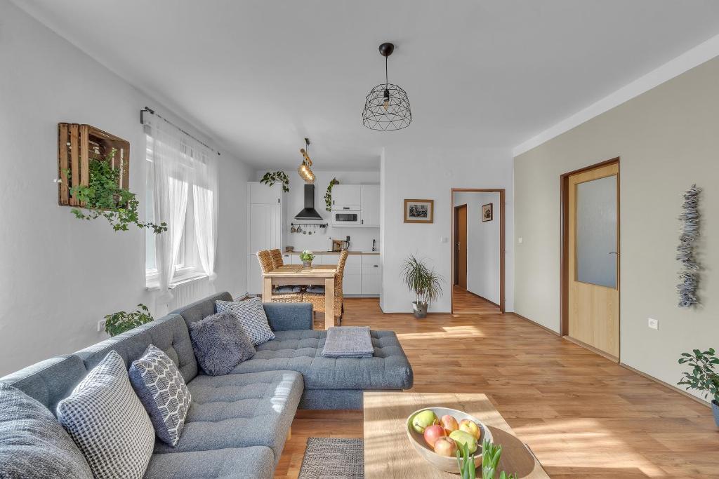 ein Wohnzimmer mit einem blauen Sofa und einem Tisch in der Unterkunft Apartmán U Javorky in Lázně Bělohrad
