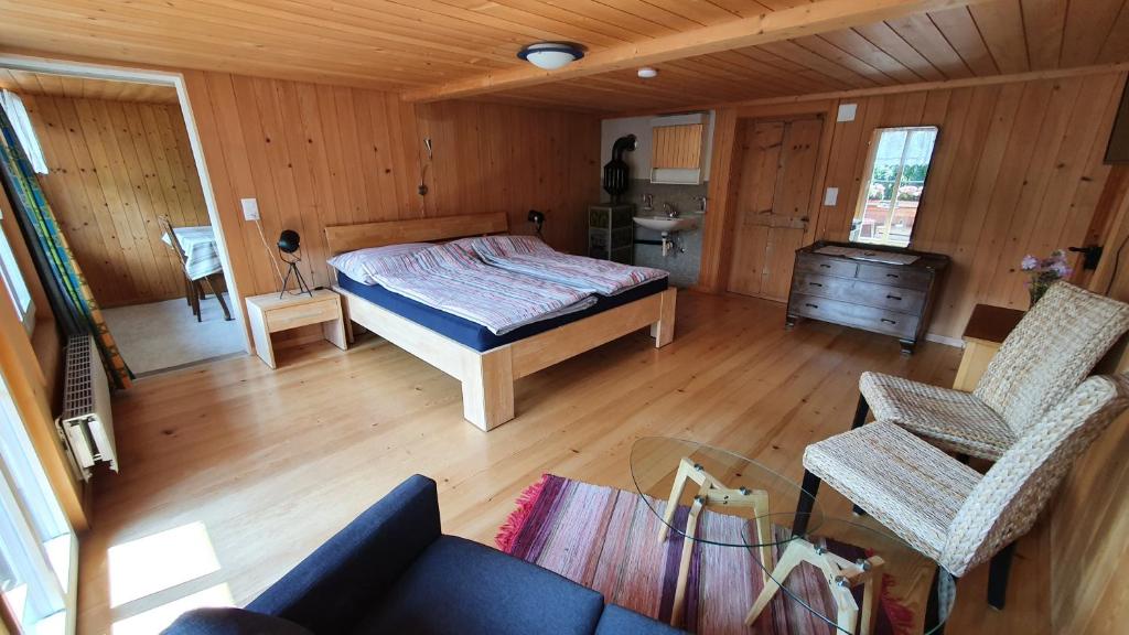 Adlerhorst - Apartment im Niedersimmetal في Oey: غرفة نوم بسرير واريكة في غرفة