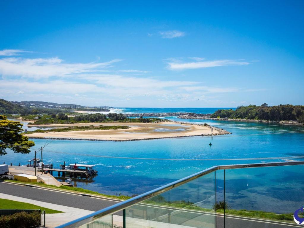 
a large body of water with a boat in the distance at Sapphire Waters Unit 3 in Narooma
