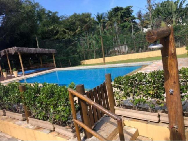 una piscina con alcune piante accanto a una recinzione di Casa em Juquehy localização e lazer perfeitos para família a São Sebastião