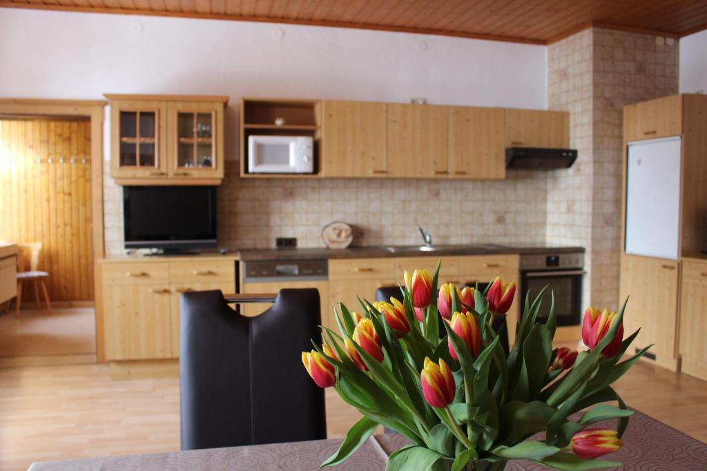 una cocina con una mesa con un jarrón de flores en Ferienwohnungen Aigner, en Haus im Ennstal