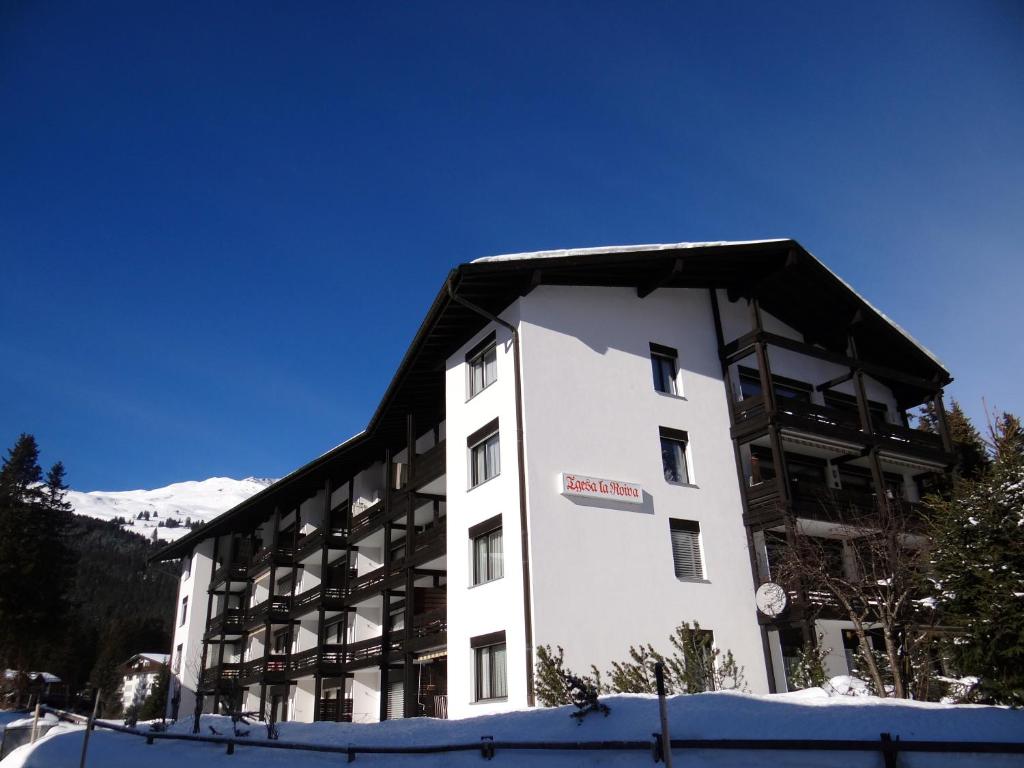 um edifício branco com um telhado preto em Apartment Tgesa La Roiva mit Hallenbad und Sauna em Lenzerheide