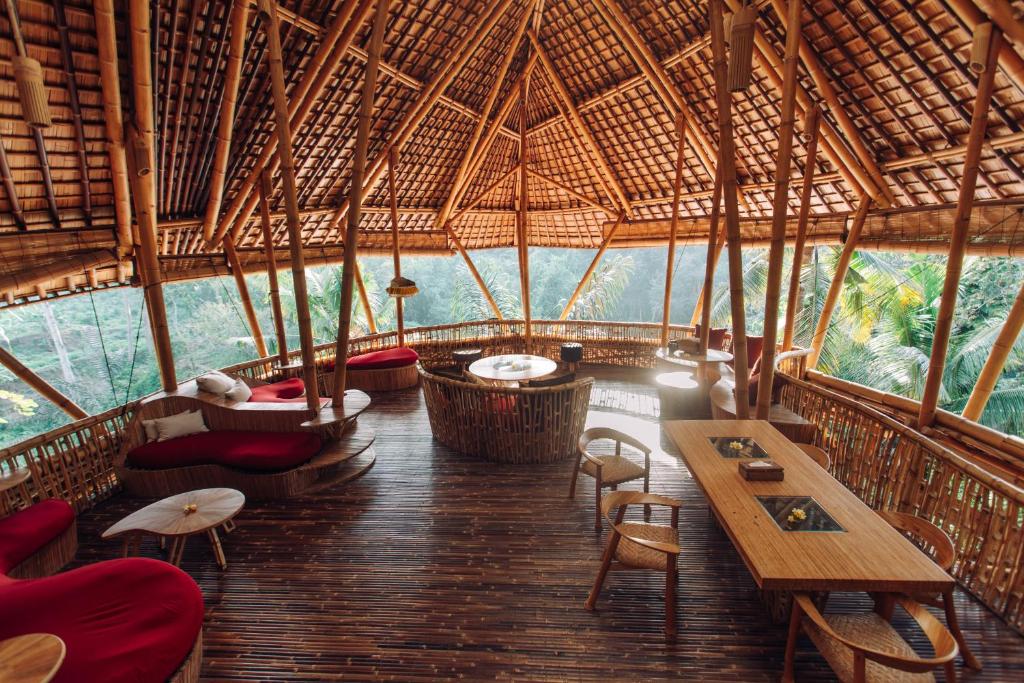 een kamer met tafels en stoelen in een bamboegebouw bij Temple House 3bds Eco Bamboo House Pool River View in Bringkit