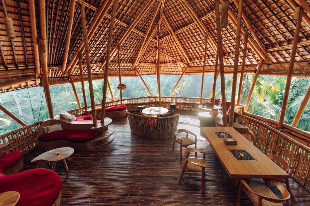 a room with tables and chairs in a bamboo building at Temple House 3bds Eco Bamboo House Pool River View in Bringkit
