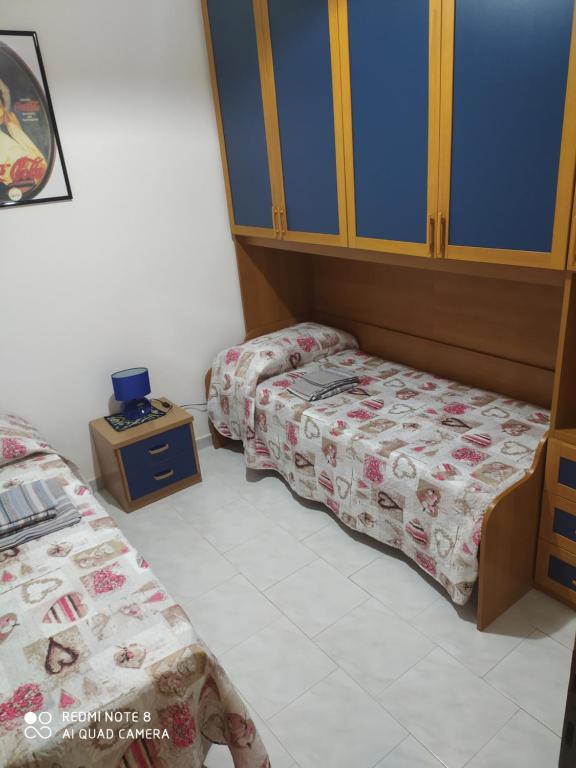 um quarto com duas camas e uma mesa de cabeceira em Buggerru Vacanze em Buggerru