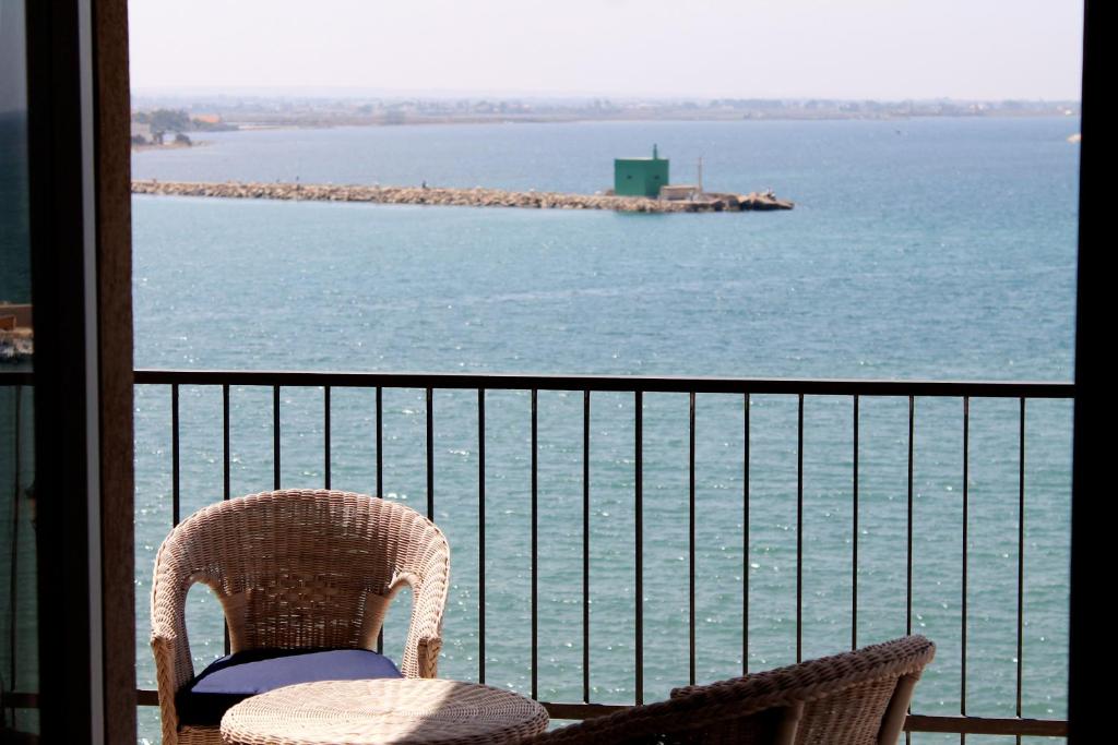 a chair sitting on a balcony looking out at the water at Atlantis in Trapani