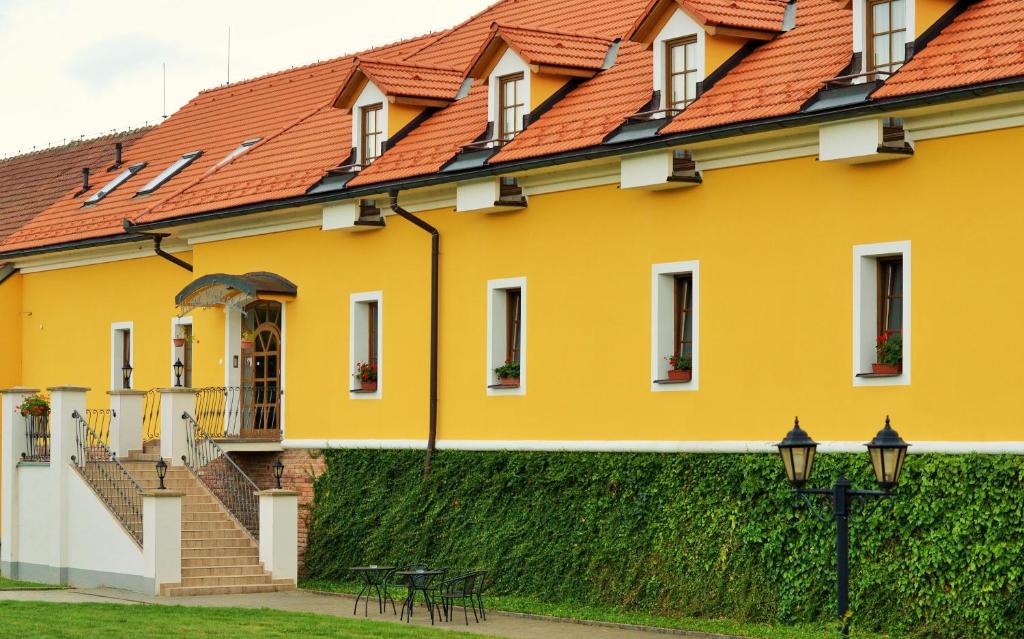a yellow building with an orange roof at Hotel Belcredi in Brno