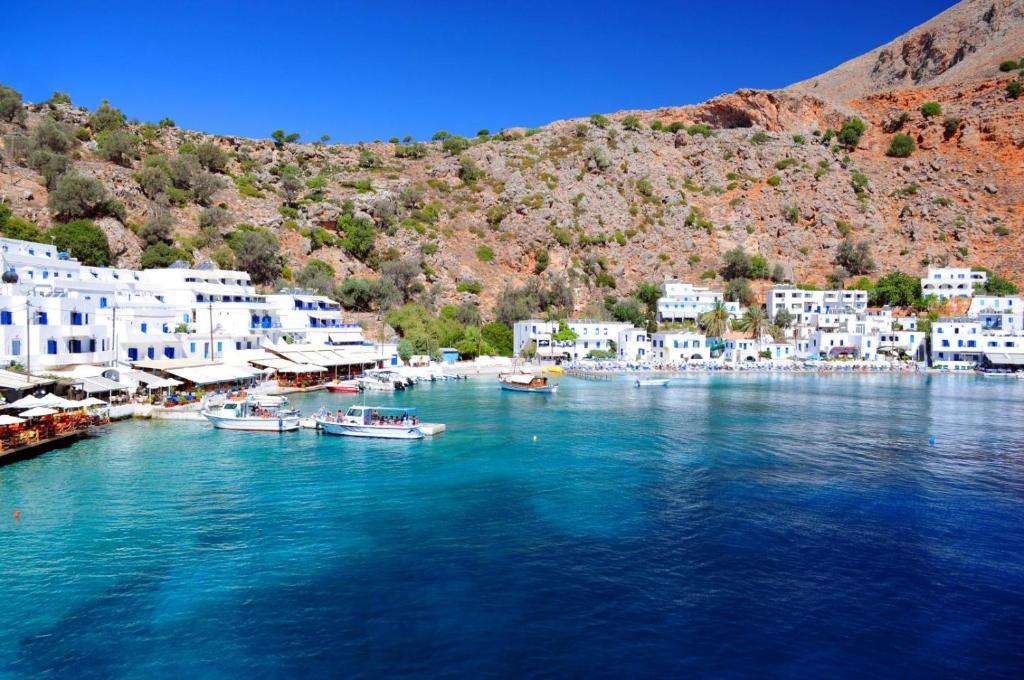 a group of boats in a body of water with buildings at Maistrali in Loutro