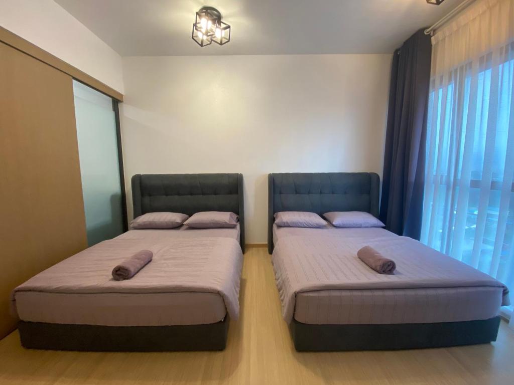 2 camas en una habitación pequeña con ventana en DSara Sungai Buloh Sentral MRT Studio Home with Two Free Parking en Sungai Buluh