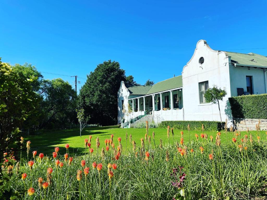 a house with a field of flowers in front of it at RHOOM in Burgersdorp