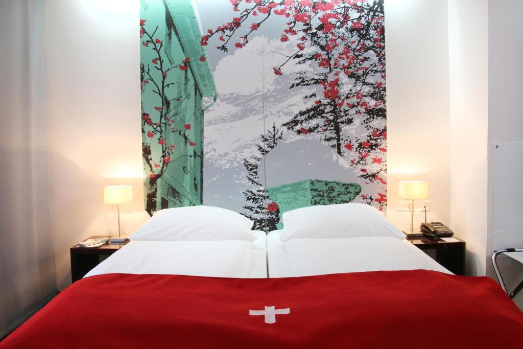 a bedroom with a red bed with a painting on the wall at Helvetia Hotel Munich City Center in Munich