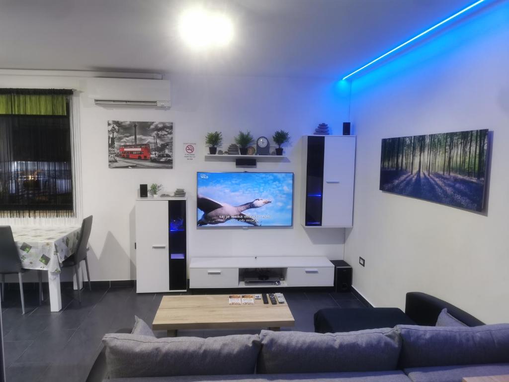 a living room with a couch and a large screen tv at Apartma Auriga in Portorož