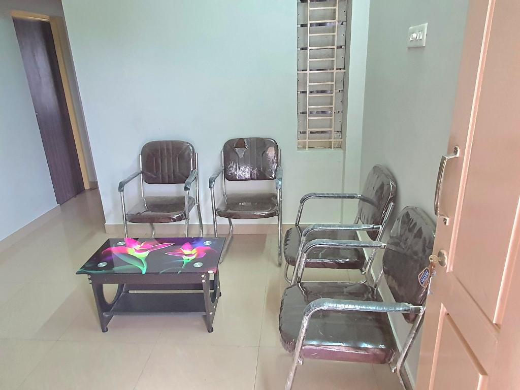 a room with chairs and a table and a table and chairs at Hallima Service Apartments Home Stay purpose Guest House 2 in Pudukkottai