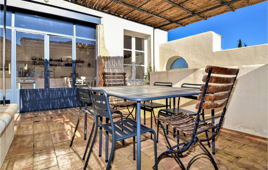 a table and chairs on the patio of a house at Nice Home In Verfeuil With Wifi, Private Swimming Pool And Outdoor Swimming Pool in Verfeuil