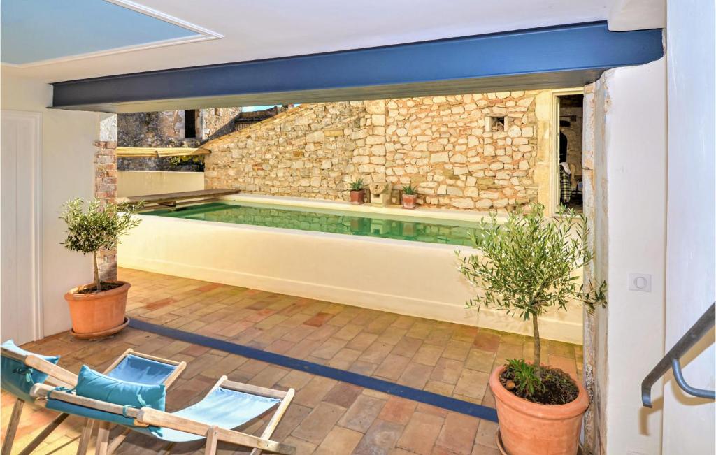 an indoor pool in a house with two chairs at Nice Home In Verfeuil With Wifi, Private Swimming Pool And Outdoor Swimming Pool in Verfeuil
