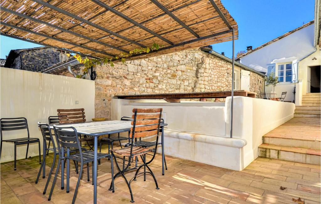 a patio with a table and chairs and a grill at Nice Home In Verfeuil With Wifi, Private Swimming Pool And Outdoor Swimming Pool in Verfeuil