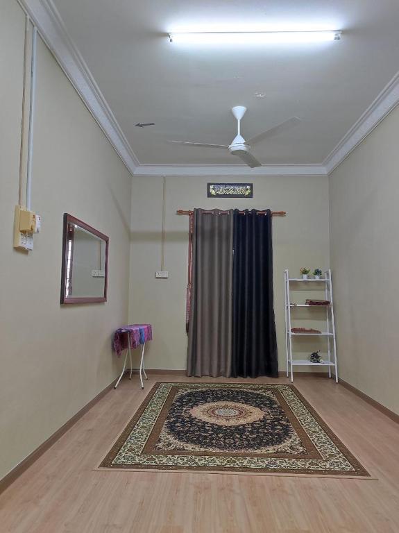 a living room with a rug on the floor at Kubang Kerian DECO HOMESTAY Aircond Wifi Netflix in Kota Bharu