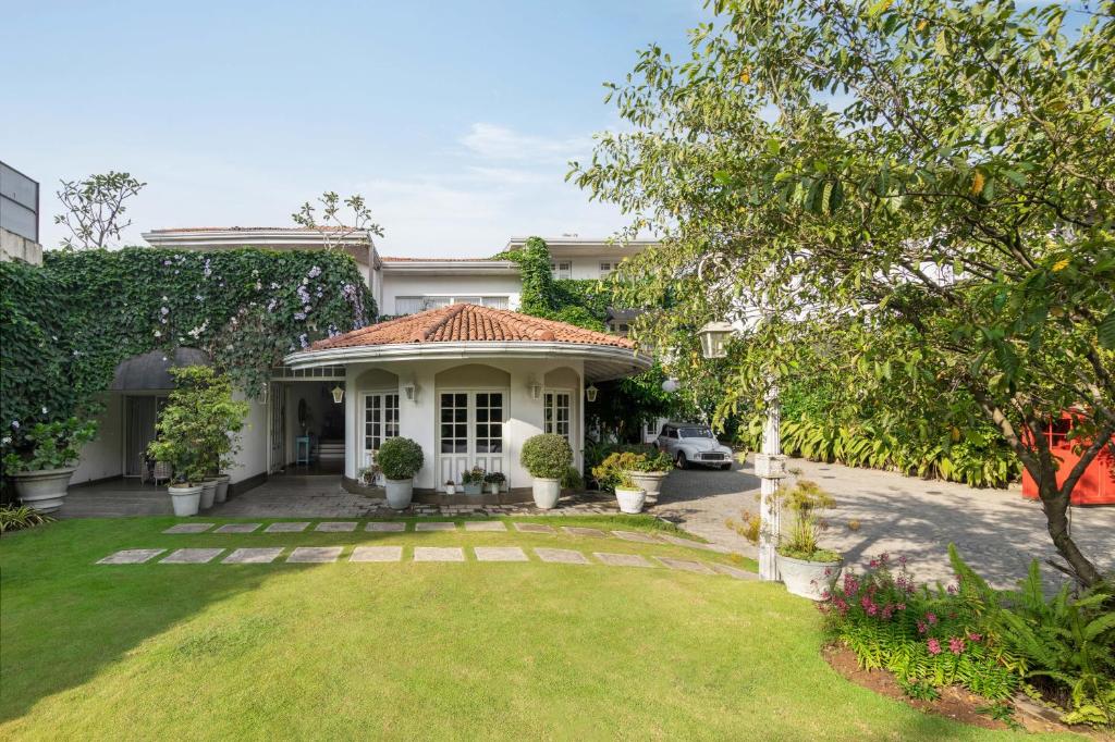 a white house with a green yard at Ru Boutique in Kandy