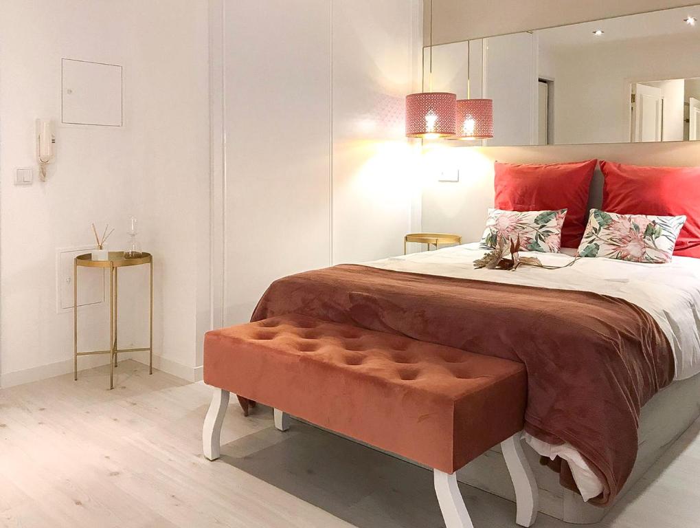 een slaapkamer met een groot bed met rode kussens bij Casa Suyay Studio in Aveiro