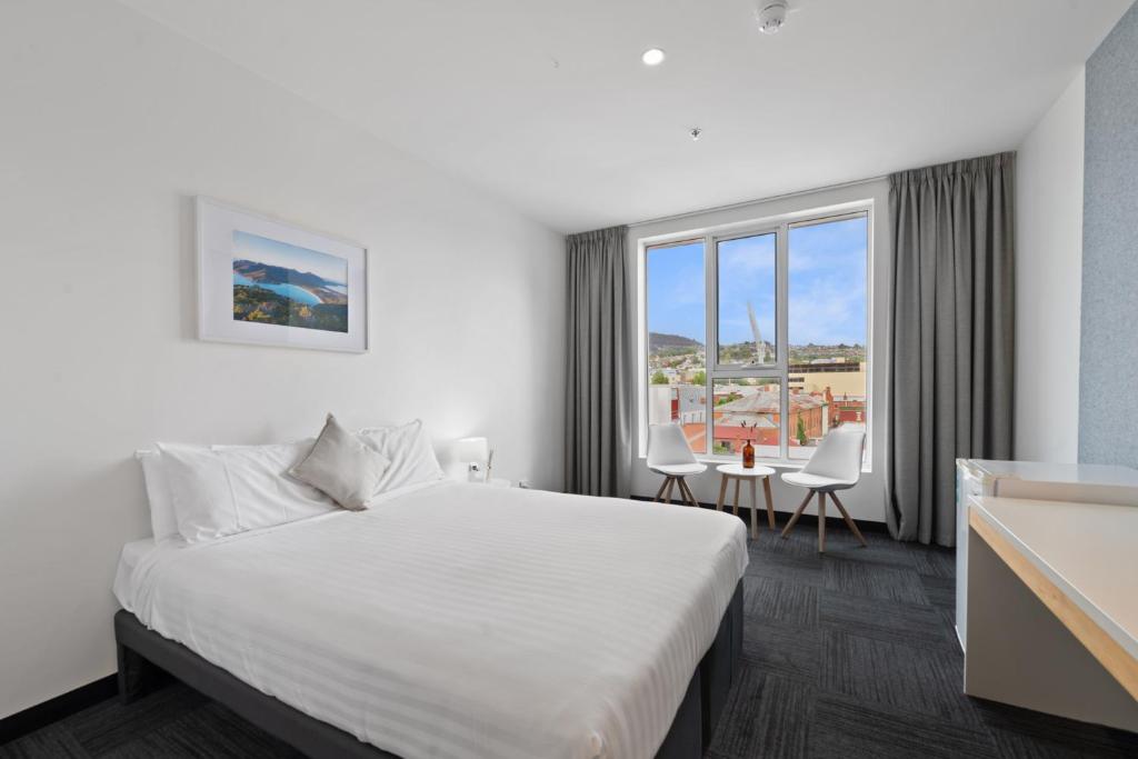 a hotel room with a bed and a large window at Allurity Hotel in Hobart