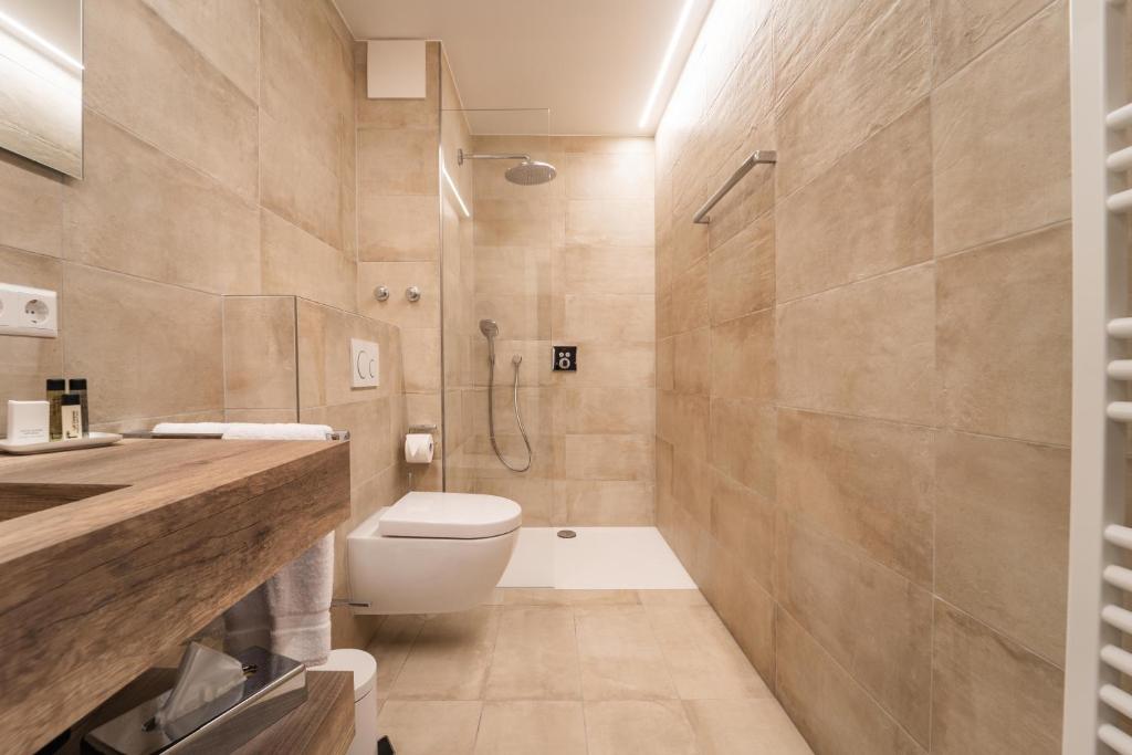 a bathroom with a toilet and a shower at Hotel Monvillage in Mondercange