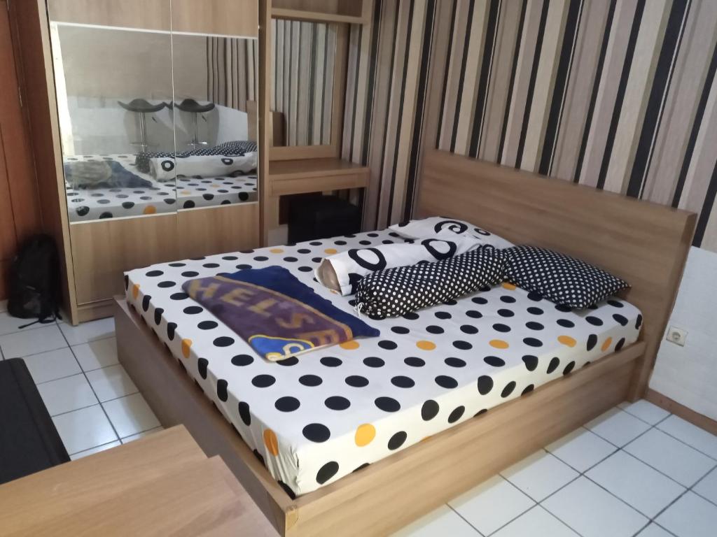 a bedroom with a bed with polka dots on it at Adhigana Property Kemang View in Pekayon Satu