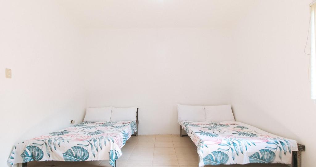 twee bedden naast elkaar in een kamer bij Dreiven Residences Sta. Mesa in Manilla