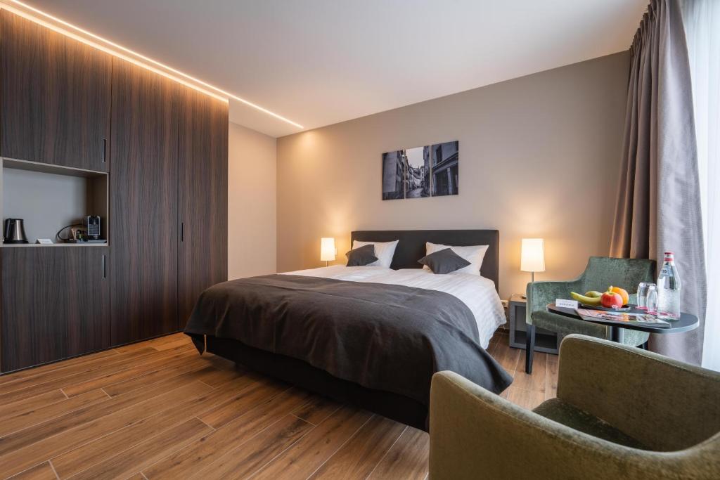 a bedroom with a bed and a table and chairs at Hotel Monvillage in Mondercange