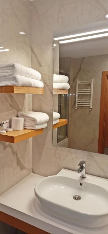 a bathroom with a sink and a mirror and towels at Silivri Park Hotel in Silivri