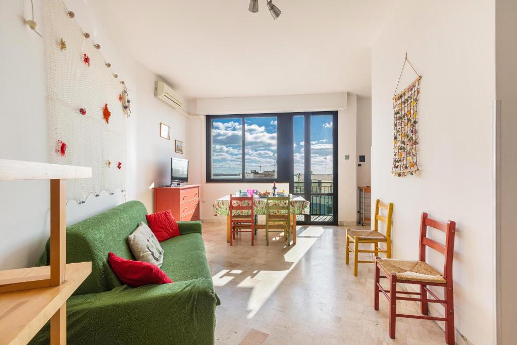 - un salon avec un canapé vert et une table dans l'établissement Appartamento Asteria by BarbarHouse, à Porto Cesareo