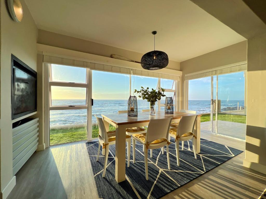 a dining room with a table and chairs and the ocean at Waterfront Edge B5 in Swakopmund