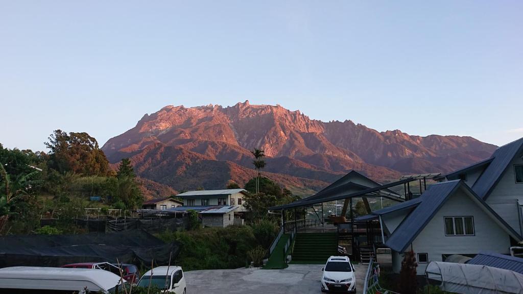a mountain in the distance with houses and cars at Amazing Grace Lodge in Kundasang