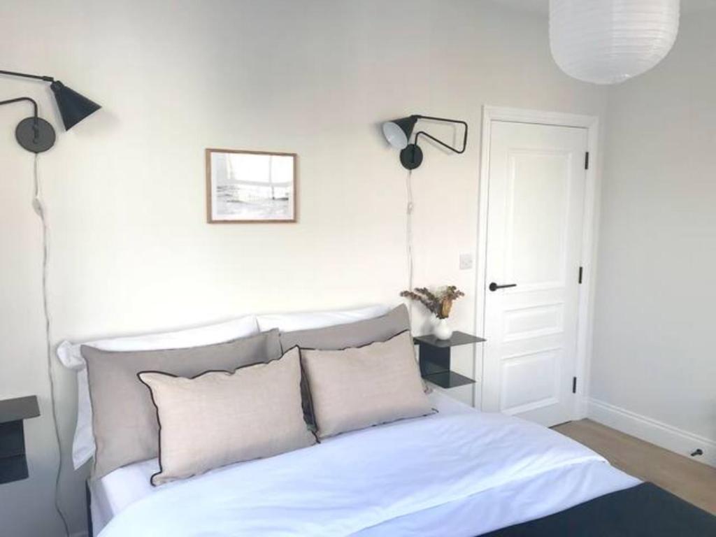 a bedroom with a white bed with two pillows at Exclusive Norman Road Apartment in St. Leonards