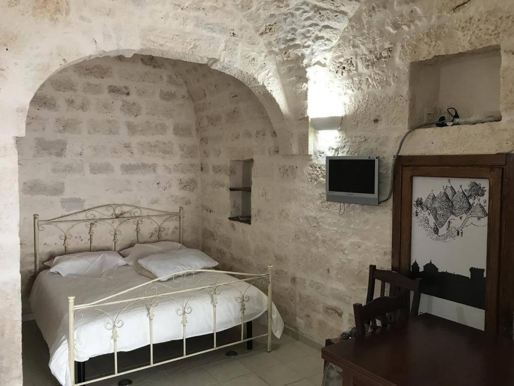 ein Schlafzimmer mit einem Bett in einer Steinmauer in der Unterkunft La casa di Gina in Ceglie Messapica