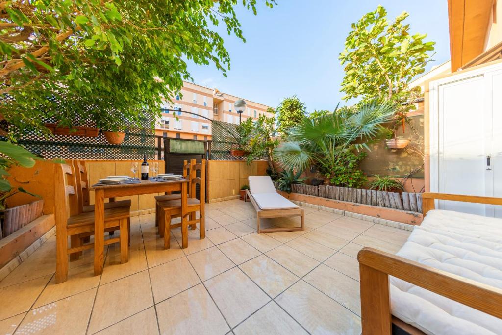 een patio met een tafel en stoelen op een balkon bij MEDANO4YOU Zoe's Garden Holiday Home in El Médano