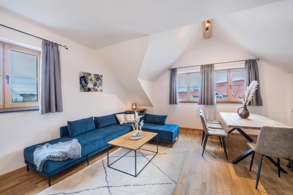 a living room with a blue couch and a table at Ferienwohnung Josef in Gilching