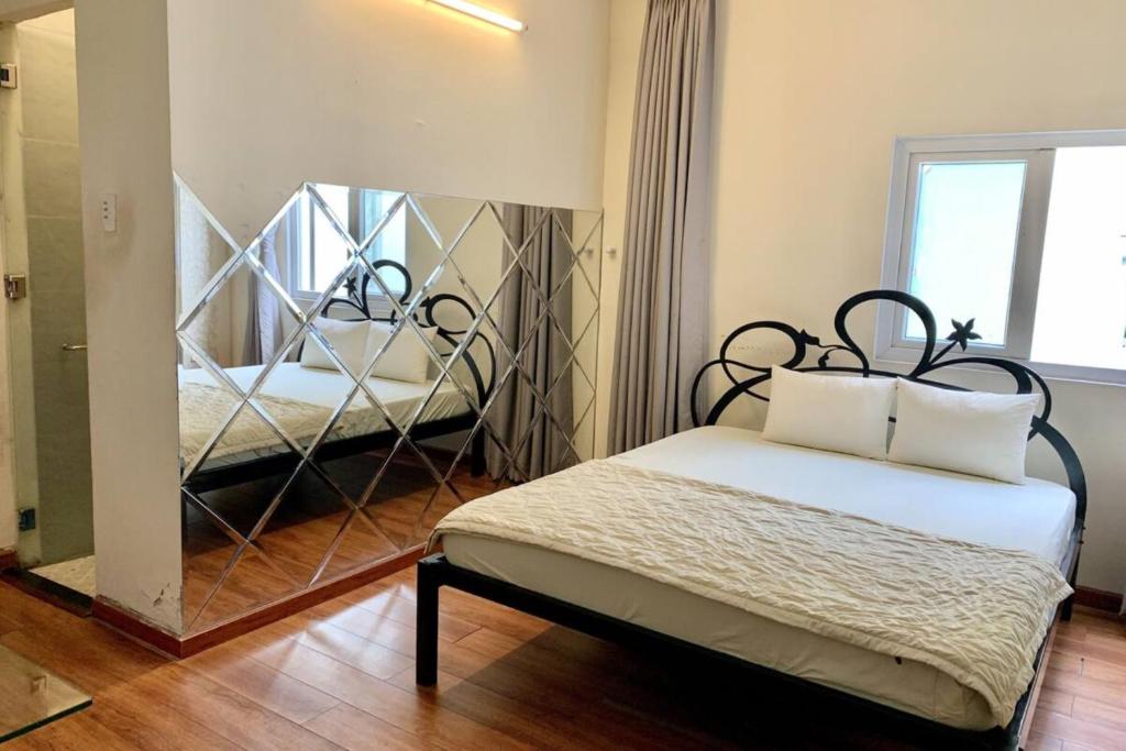- une chambre avec un miroir et un lit dans une pièce dans l'établissement Bao Ngoc Hotel, à Hô-Chi-Minh-Ville