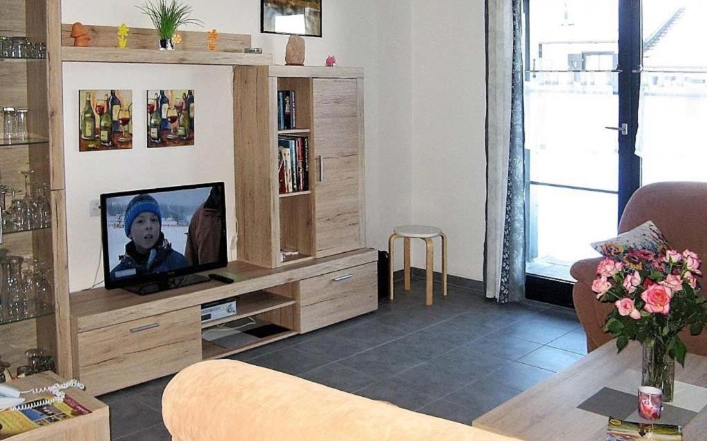 ein Wohnzimmer mit einem TV in einem hölzernen Unterhaltungszentrum in der Unterkunft Ferienhaus Nr 3, Typ A, Feriendorf Hochbergle, Allgäu in Bichel