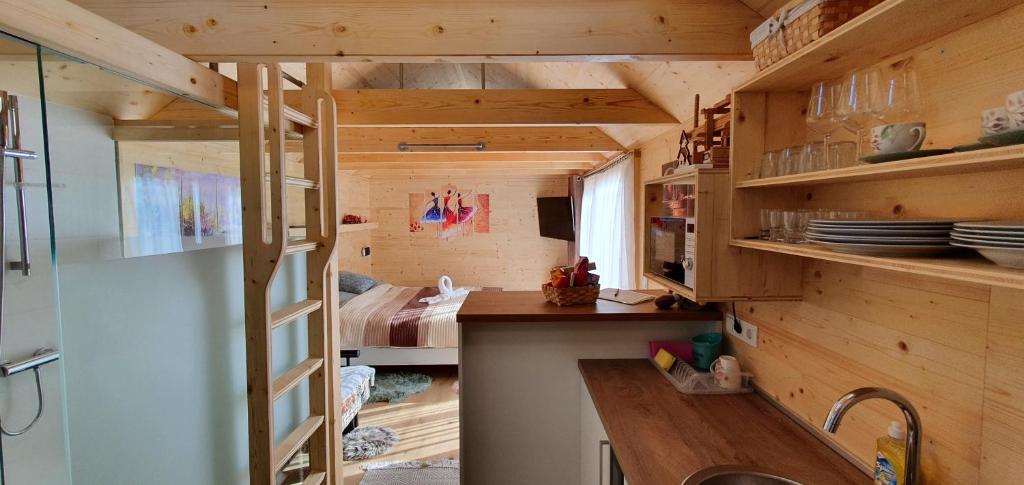 a tiny house with a kitchen and a bedroom at Apartma, glamping Na koncu vasi in Ljutomer