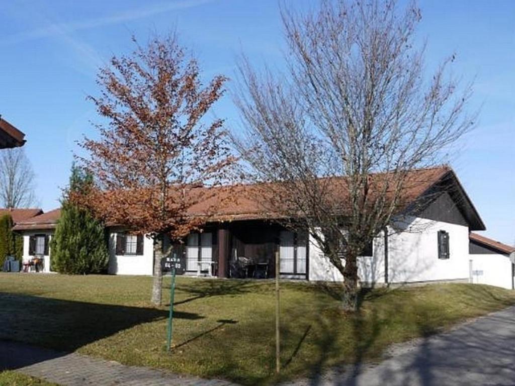 uma casa com duas árvores em frente em Ferienhaus Nr 59, Kategorie Komfort, Feriendorf Hochbergle, Allgäu em Karlsebene