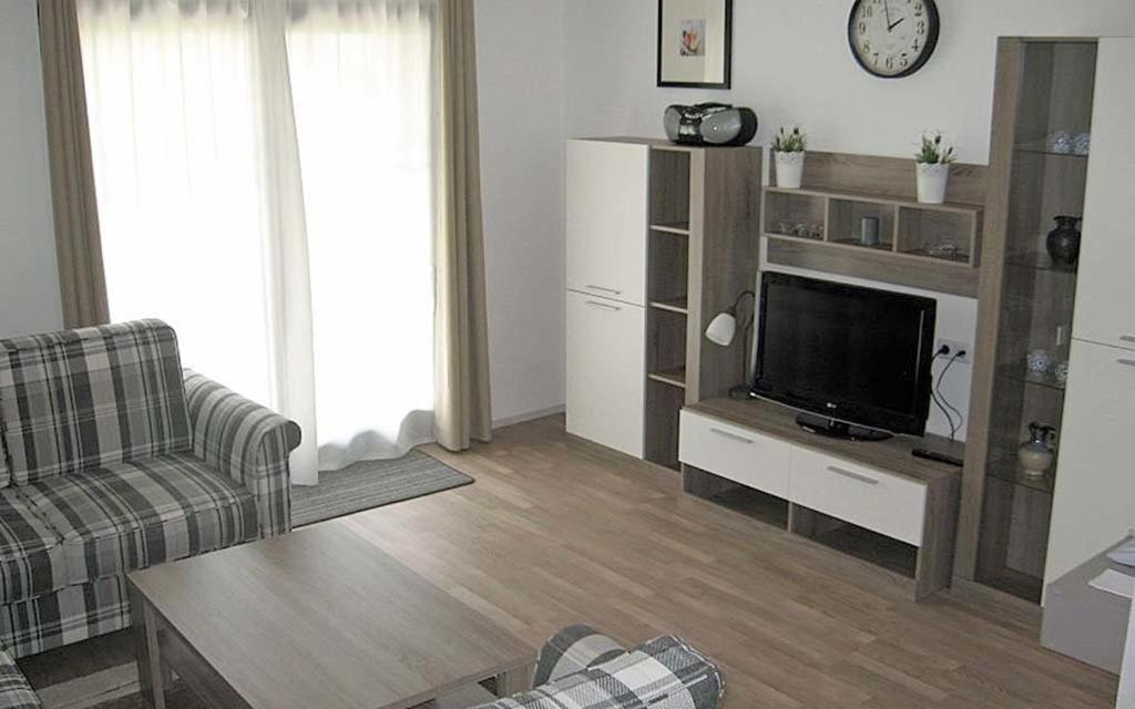 uma sala de estar com um sofá e uma televisão em Ferienhaus Nr 18, Kategorie Komfort, Feriendorf Hochbergle, Allgäu em Bichel