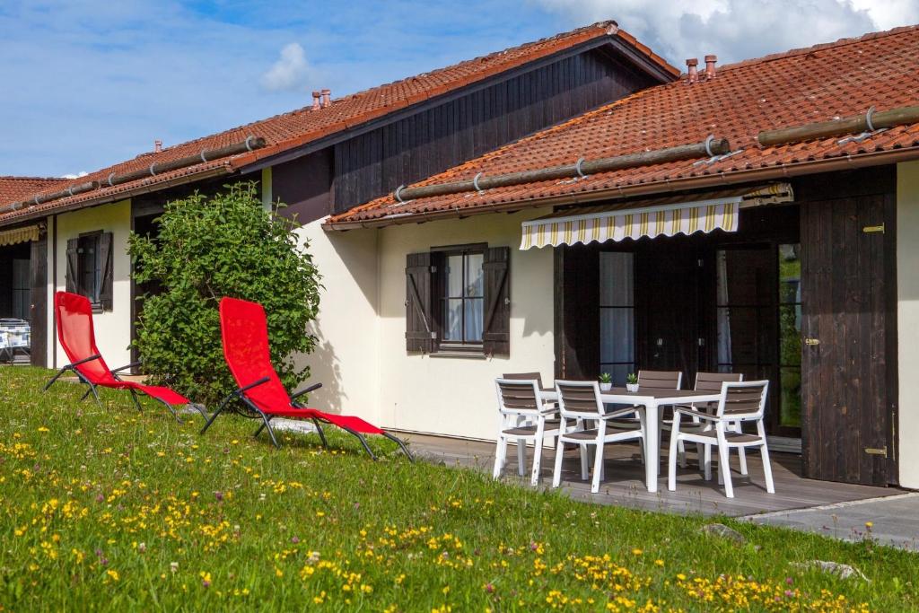 een huis met een tafel en stoelen in de tuin bij Ferienhaus Nr 49, Kategorie Premium, Feriendorf Hochbergle, Allgäu in Karlsebene