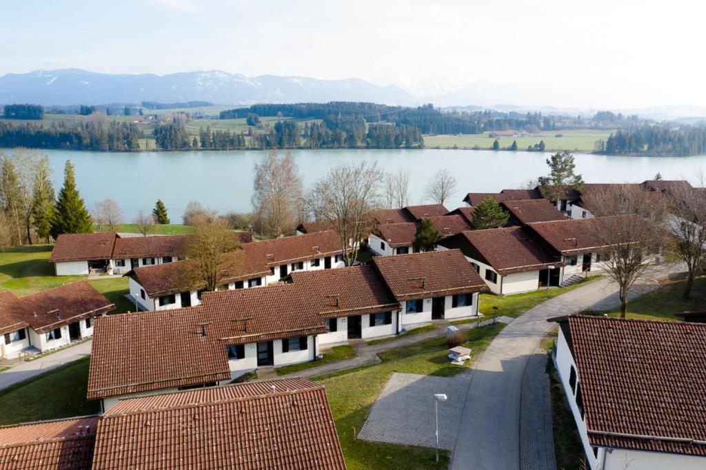 a row of houses with a lake in the background at Ferienhaus Nr 50, Kategorie Premium, Feriendorf Hochbergle, Allgäu in Karlsebene